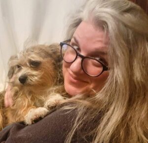 Headshot of Melanie Slavitch holding a dog.