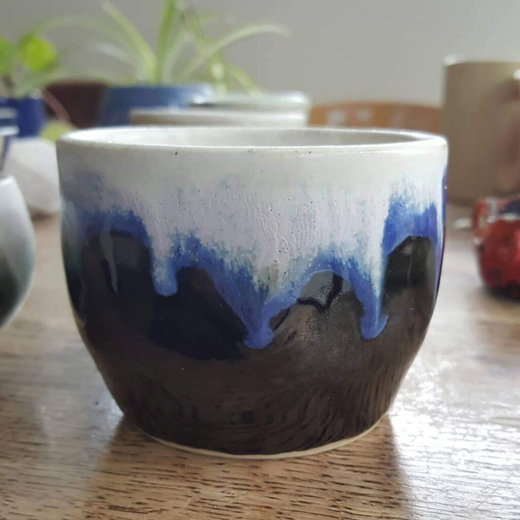 Deep blue clay bowl with melting snow-like paint around the rim