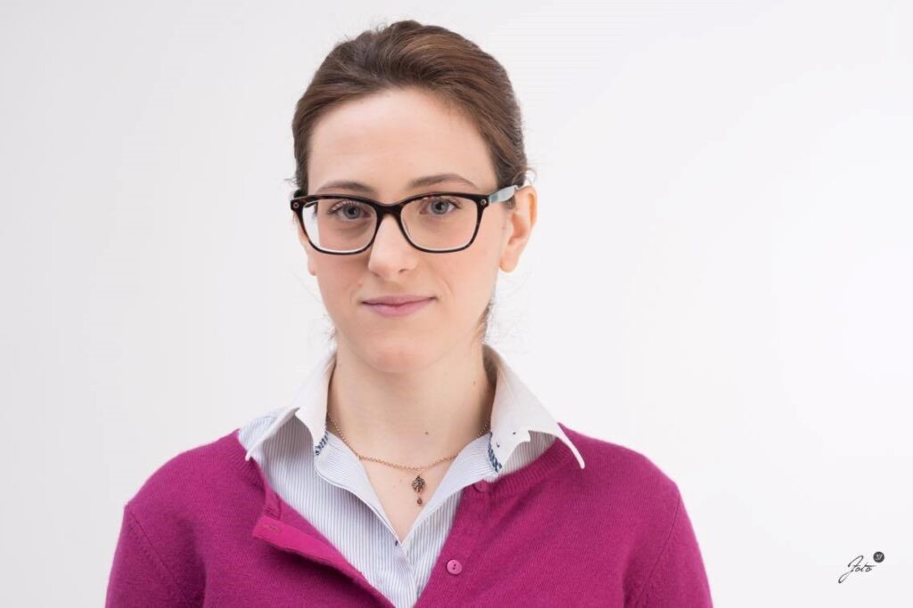 Camilla Negri A photo of Camilla Negri wearing a collared shirt and pink cardigan.
